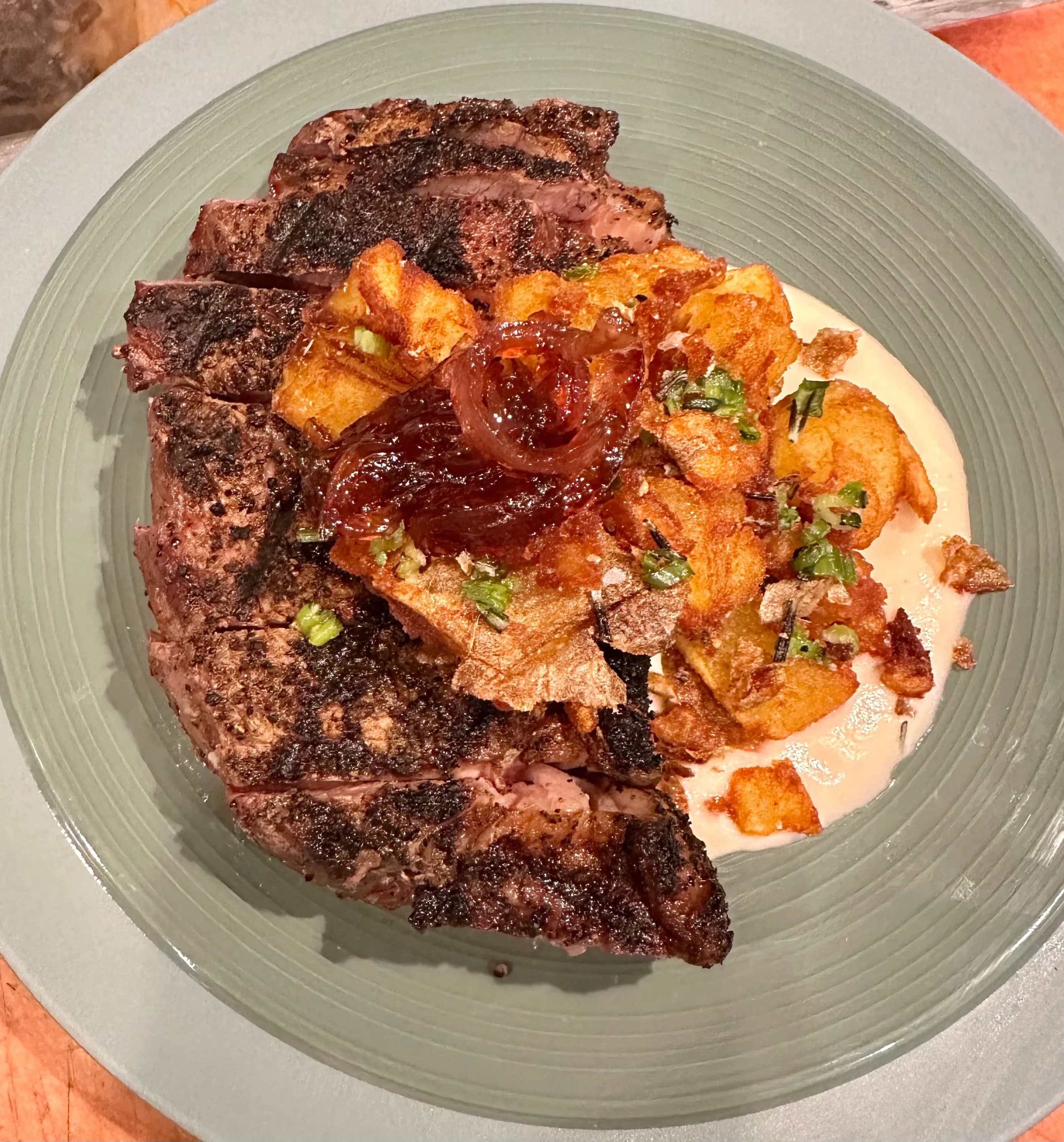 Grilled steak with crispy potatoes and caramelized onions