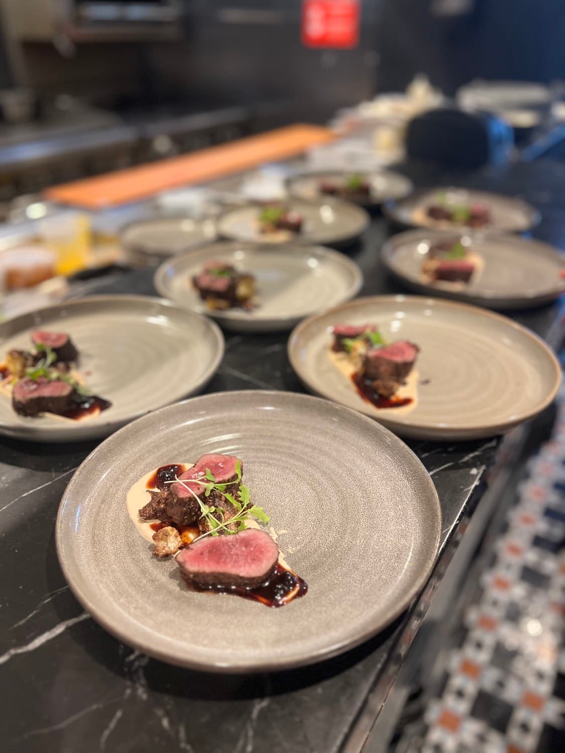 A sequence of private dinner courses prepared for service